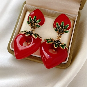 Nahaufnahme vintage roter Herzohrringe aus Harz mit Blattgold-Detail in einer Box