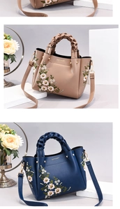 Detailed embroidery on a leather handbag with woven handles in brown and navy colors