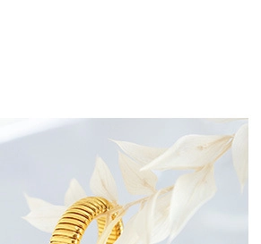Detailed view of gold plated spiral ring with horizontal ribbed textures and layered metallic bands