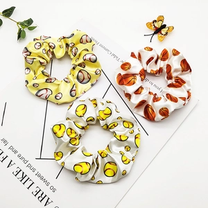 Set of three satin hair scrunchies featuring sports ball prints including basketball and baseball