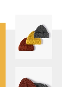 Detailed honeycomb knit texture of wool beanies in dark grey, yellow, and caramel brown