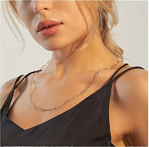 Golden paperclip chain necklace in stainless steel shown on a female model's neckline