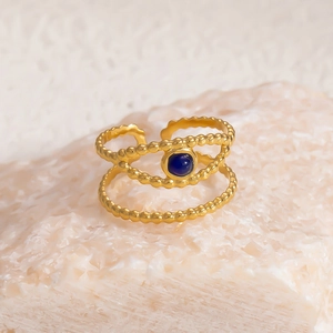 Detail of an 18k gold open ring featuring double-beaded bands and a blue natural stone