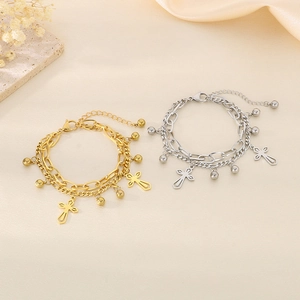 Close-up of double-layer gold and silver stainless steel bracelets with cross charms