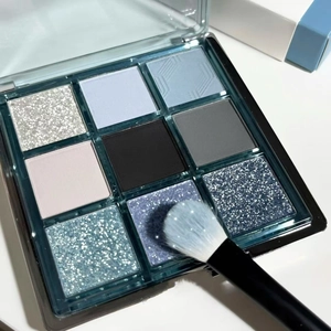 Detailed top view of nine-color eyeshadow palette with cool blue and silver tones