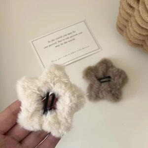 Close-up of plush star hair clips in beige and brown colors with soft furry texture