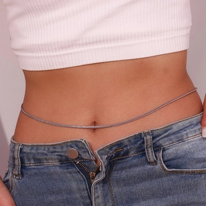 Minimalist silver metal waist chain jewelry shown on a model with a bare midriff look