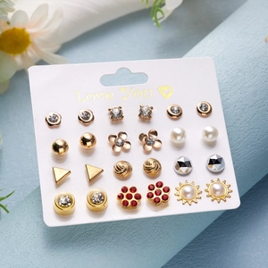 Macro shot of a 12-pair stud earring set with floral, heart, and star designs on a display card