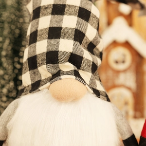 Close-up of a Christmas gnome with a black and white checkered hat and fluffy white beard