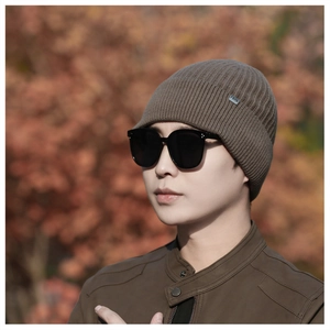 Detail of a brown ribbed knit beanie with a metal tag showing the F2KS logo