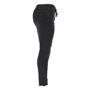 Détail d'un jean skinny noir avec taille à cordon et déchirures stylées aux genoux