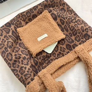 Close-up of leopard print tote bag with brown sherpa pocket and white woven label detail