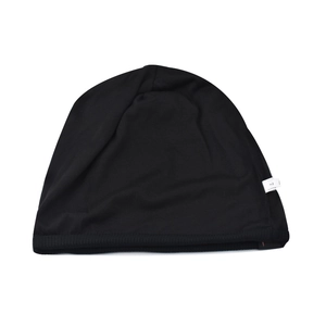 Détail du bonnet noir en maille montrant le bord élastique et l'étiquette d'entretien