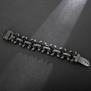 Vintage stainless steel and black leather motorcycle bracelet for men on grey background