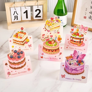 Detail of 3D birthday cards with cake illustrations on a marble table background