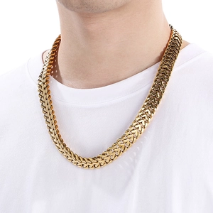 Detail of chunky gold heart chain bracelet on male model showing metallic texture