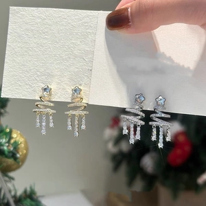 Close-up of elegant Christmas tree tassel earrings with sparkling rhinestones in gold and silver