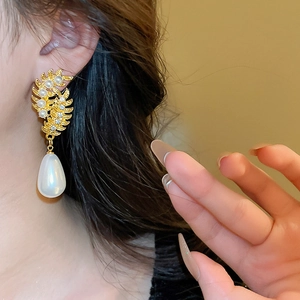 French vintage gold leaf earrings with rhinestones and white teardrop pearls on a model