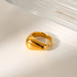 Close-up of a polished gold teardrop open ring with high-gloss finish and 3D design