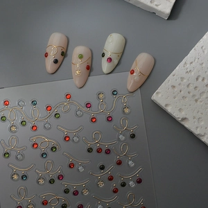 Detail of Christmas nail art stickers with gold lines, colorful rhinestones and snowflakes