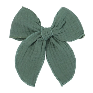 Detail of 5.4-inch dark green muslin cotton bow clip with natural wrinkled texture