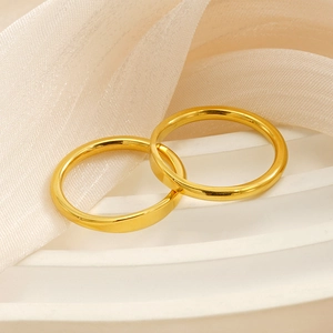 Close-up of dual 18k gold-plated minimalist steel rings on elegant silk and pedestal