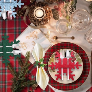 Close-up of snowflake felt cutlery holders in festive red, green, and blue on a holiday table