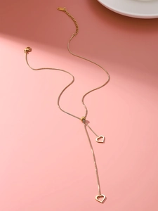 Close-up of adjustable gold titanium steel necklace with two hollow heart pendants