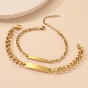 Detailed view of two gold stainless steel bracelets with blank rectangle ID plates and lobster clasp