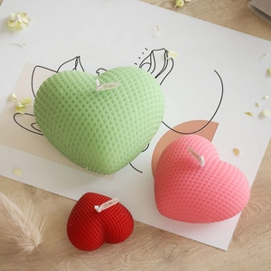Dettaglio trama a nido d'ape su candele a cuore intrecciate menta, rosa e rosso