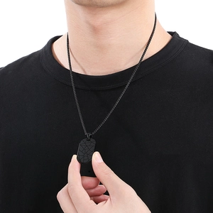 Detail of men's black stainless steel rectangle pendant necklace with crack texture