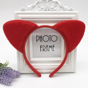 Detail of red plush cat ear headband with soft faux fur on a white display frame