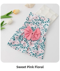 Close-up of cute floral dog dress featuring pink flower prints and a large satin bow accent