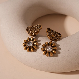 Detail of vintage gold bear and flower earrings with sparkling zircon accents