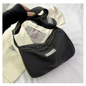 Detail of black nylon hobo bag with wide strap and round coin purse attachment
