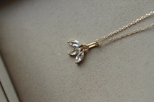 Detailed macro view of gold S925 silver necklace with three marquise-cut clear crystals