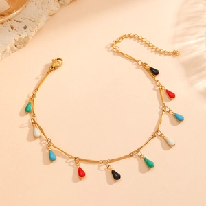 18K gold-plated bracelet with multi-colored water-drop pendants on a textured stone surface