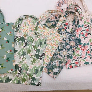 Vue à plat de plusieurs sacs cabas en toile florale montrant divers motifs et boucles