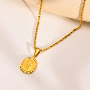 Detailed macro shot of a gold sunflower embossed oval pendant on a twist style chain