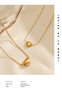 Détail artistique de colliers cœur plaqués or 18 carats sur tissu beige doux