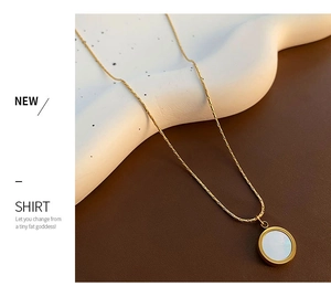 Detailed shot of 18K gold snake chain necklace with white mother of pearl pendant