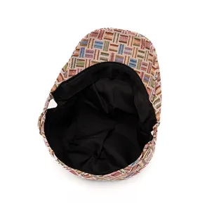 Detailed interior view showing black fabric lining and colorful woven stitching of beret