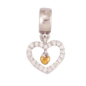 Detailed view of silver heart charm with cubic zirconia and gold mini heart pendant
