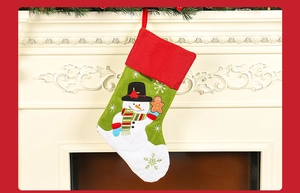Broderie détaillée d'un bonhomme de neige sur une chaussette de Noël verte décorative