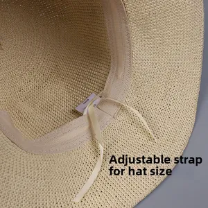 Detail view of the straw hat interior featuring an adjustable satin drawstring for sizing