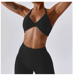 Detail of black halter yoga bra with twist front knot and matte high-waisted leggings