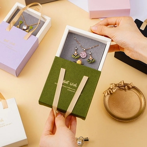 Chic drawer-style jewelry boxes in multiple colors with silk handles and gold accents