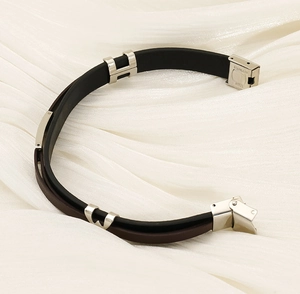 Detail of double-layer leather bracelet with silver stainless steel clasp on silk fabric