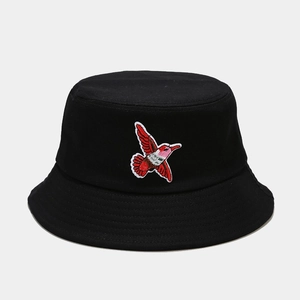 Close-up of intricate red and white hummingbird embroidery on a black cotton bucket hat