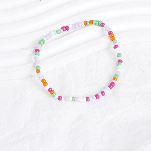 Close-up of colorful Bohemian seed bead bracelets on a clean white textured background